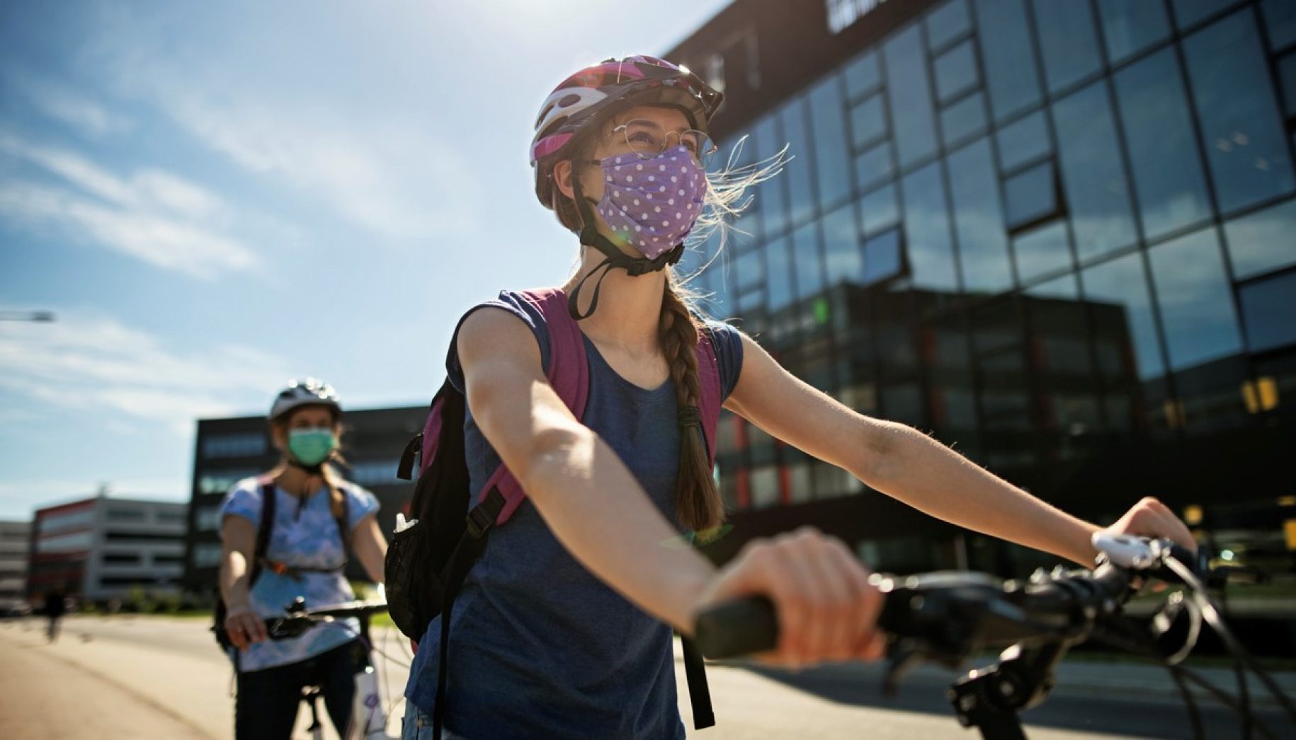 Mother and daughter are enjoying a bike trip together in the modern residential area. They are wearing obligatory face masks.
Nikon D850